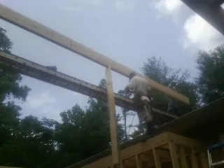 Carpenter setting a ridge beam over a new addition frame — Ice Dam Removal by Roofing Brothers in Saint Pauls