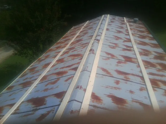 Rusted metal roof panels with new wood purlins before replacement — Storm Damage Roof Repair in Saint Pauls by Roofing Brothers