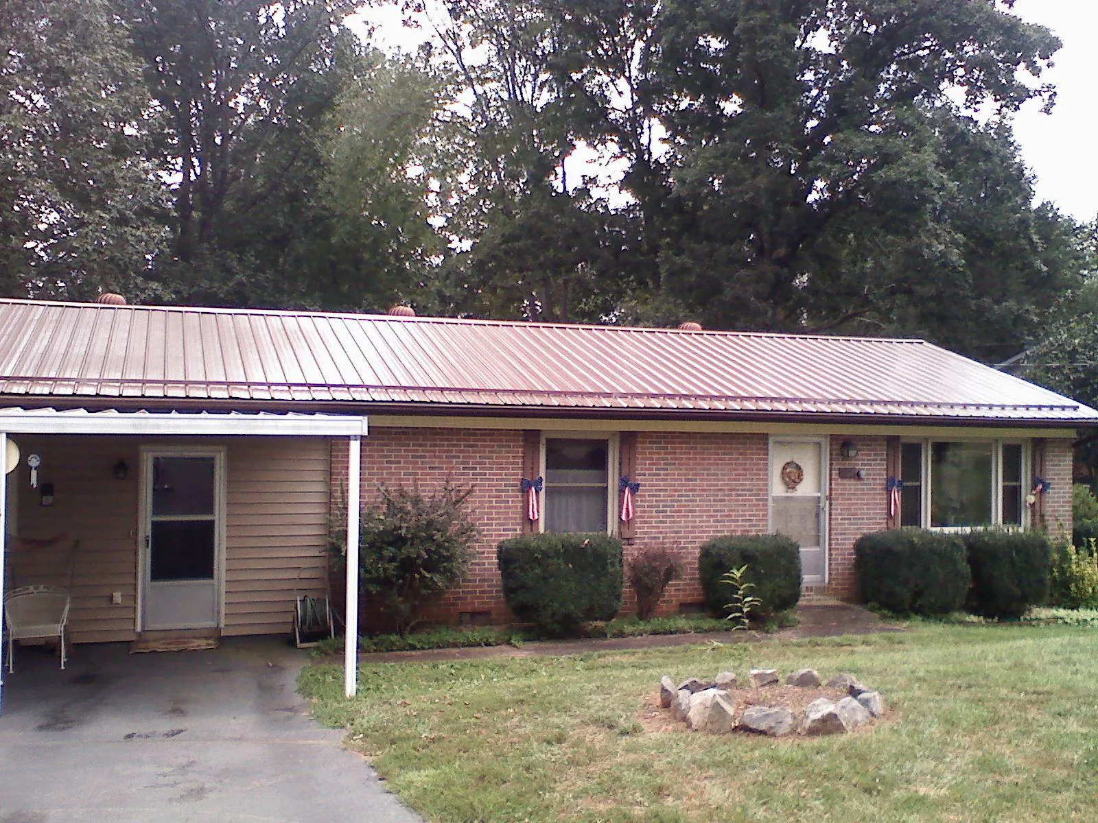 Bronze metal roof and carport on a brick ranch home — Roof Repair work by our crew in Saint Pauls